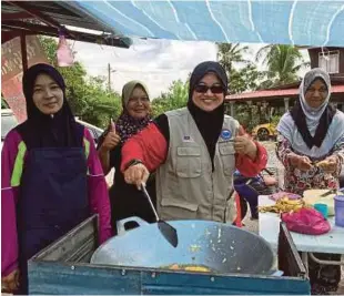  ??  ?? KEGIGIHAN Azzah turun padang berbakti kepada mereka yang memerlukan.