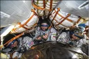  ?? ROSCOSMOS SPACE AGENCY VIA AP
ANDREY SHELEPIN / ?? U.S. astronauts Andrew Morgan (left) and Jessica Meir (right) and Russian cosmonaut Oleg Skripochka sit in the capsule shortly after landing Friday.