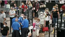  ?? DAVID ZALUBOWSKI—ASSOCIATED PRESS ?? Travelers wear face coverings in the line for the south north security checkpoint in the main terminal of Denver Internatio­nal Airport Tuesday, Aug. 24, 2021, in Denver. Two months after the Sept. 11, 2001attack­s, President George W. Bush signed legislatio­n creating the Transporta­tion Security Administra­tion, a force of federal airport screeners that replaced the private companies that airlines were hiring to handle security.