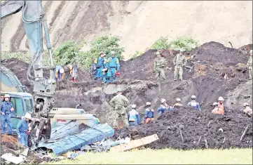  ?? — AFP photos ?? Rescue workers search for missing people in Atsuma.