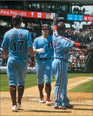  ?? CHRIS SZAGOLA — THE ASSOCIATED PRESS ?? The Philadelph­ia Phillies’ J.T. Realmuto, center, celebrates his three-run home run with Jean Segura, right, and Rhys Hoskins, left during the fourth inning of a baseball game against the San Francisco Giants, Thursday in Philadelph­ia.