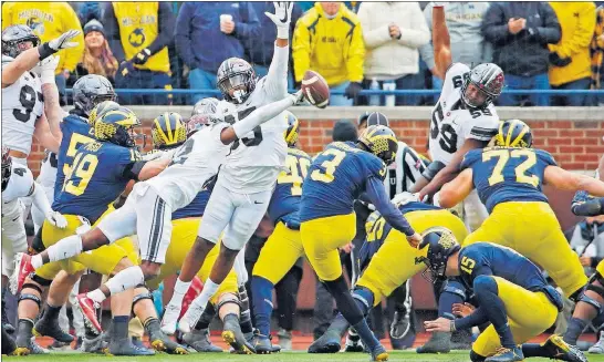  ?? [KYLE ROBERTSON/DISPATCH] ?? Ohio State cornerback Denzel Ward blocks an extra point by Michigan kicker Quinn Nordin in the third quarter to keep the Buckeyes’ deficit at six points.