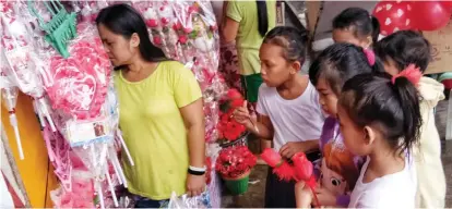  ?? ALDO
NELBERT BANAYNAL ?? Students of Mabolo Elementary School in Cebu City drop by a store to buy flOwErs ANDother gift items for their teachers on Valentine's Day.