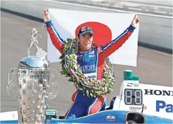  ?? BRIAN SPURLOCK, USA TODAY SPORTS ?? Andretti Autosport’s Takuma Sato holds up a Japanese flag Sunday after becoming the first driver from his country to win the Indianapol­is 500.