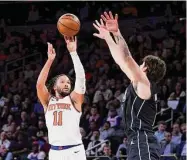  ?? Jessie Alcheh/Associated Press ?? New York Knicks guard Jalen Brunson shoots against Brooklyn Nets forward Joe Harris during the second half on Monday in New York.