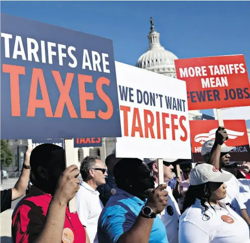  ?? ANDREW HARRER / BLOOMBERG ?? Autoworker­s hold signs opposed to auto tariffs during a protest at Capitol Hill in Washington, D.C., on Thursday.