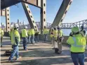  ?? KENTUCKY TRANSPORTA­TION CABINET ?? Kentucky and Ohio transporta­tion officials inspect the scorched bridge Thursday after debris from colliding semi-trucks was removed.