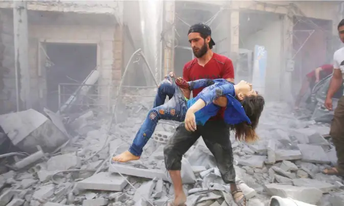  ??  ?? In this file photo taken on May 26, 2019, a man evacuates a young bombing casualty after a reported air strike by regime forces and their allies in the jihadist-held Syrian town of Maaret Al-Noman in the southern Idlib province.