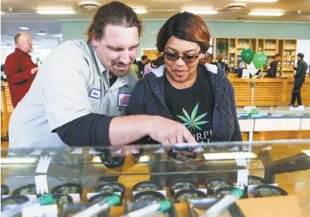  ?? Photos by Amy Osborne / Special to The Chronicle ?? Robert Thompson and Ranita Reed shop at Harborside in Oakland on the first day of legal recreation­al marijuana sales.