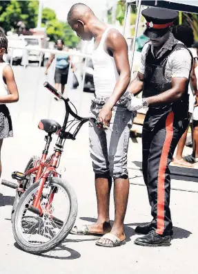  ?? FILE ?? A resident of Regent Street is searched by a policeman during the second declared ZOSO in Denham Town, Kingston, last year.