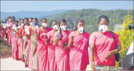  ?? PTI ?? ASHA workers with their identity cards wait in a queue to get vaccinated in Karnataka.