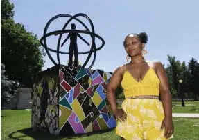  ??  ?? Keisha Marie Fadeyi stands in front of her artwork, second panel from the left of a shared, four-panel piece surroundin­g the Christophe­r Columbus statue.