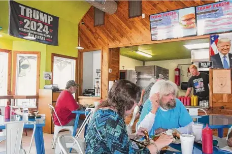  ?? Photos by Brett Coomer/Staff photograph­er ?? Margie Johnson, left, and Hub Gambel have lunch at Trump Burger in Bellville in Austin County, a Donald Trump stronghold.