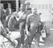  ?? AP 1963 ?? Revs. Ralph Abernathy, left, and Martin Luther King Jr. are taken by a policeman as they lead demonstrat­ors in a march to end racial segregatio­n in Birmingham, Alabama.