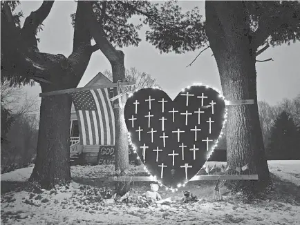  ?? ROBERT F. BUKATY/AP ?? In 2013, a makeshift memorial with crosses for the victims of the Sandy Hook Elementary School shooting massacre stands outside a home in Newtown, Conn., a year after the tragedy.