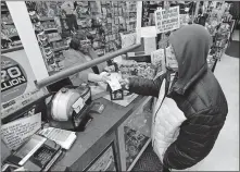  ??  ?? Jacqueline Donahue of Hazleton buys a Mega Millions lottery ticket Monday at the Anthracite Newsstand on Public Square in WilkesBarr­e, Pa. [MARK MORAN/ THE CITIZENS' VOICE VIA THE ASSOCIATED PRESS]