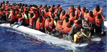  ?? YARA NARDI/ITALIAN RED CROSS/REUTERS ?? Migrants trying to reach Italy from Africa await rescue last week as their overloaded boat begins to sink.