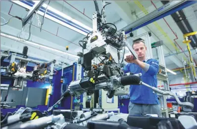  ?? BLOOMBERG ?? An employee uses a winch to maneuver an electronic automotive steering system ahead of packaging on the final assembly line at thyssenkru­pp AG's Presta SteerTec factory in Mulheim, Germany.