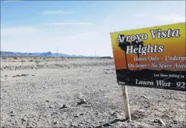  ??  ?? A sign on a vacant lot at the failed Arroyo Vista Heights subdivisio­n project is seen Jan. 6 on Corwin Road in Bullhead City, Ariz. The city is slowly rebounding after the housing bubble burst during the Great Recession, but lags Las Vegas to the...
