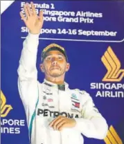  ?? REUTERS ?? Mercedes' Lewis Hamilton celebrates on the podium after winning the Singapore Grand Prix on Sunday.