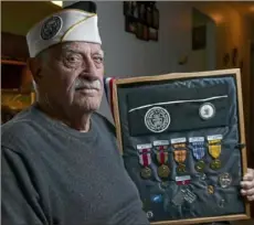  ?? Nate Guidry/Post-Gazette ?? Pearl Harbor survivor Isaac George, 97, shows off his medals Wednesday at his home in Neshannock Township.