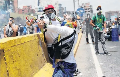  ?? PHOTO: REUTERS ?? Street warfare . . . Opposition supporters clash with security forces during a rally against Venezuela’s President Nicolas Maduro in Caracas yesterday.