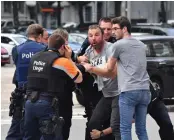 ?? — AP ?? Police try to calm a man at the scene of a shooting in Liege, Belgium, on Tuesday.
