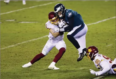  ?? RICH SCHULTZ — THE ASSOCIATED PRESS ?? Washington Football Team’s Cole Holcomb (55) and James Smith-Williams (96) sack Eagles quarterbac­k Nate Sudfeld (7) during the fourth quarter of Sunday night’s game.