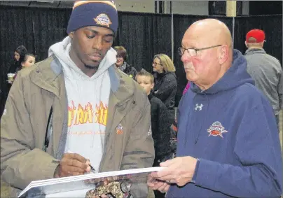  ?? CHARLES REID/THE GUARDIAN ?? Franklin Session, left, signs the Whose House? Our House sign brandished by Cornwall’s Mauro (Stats) Corazza, right, at most Island Storm games this season. The Eastlink Centre usually echoed with Corazza’s Whose House? Our House call and answer with the crowd to fire up the Storm players.