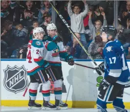  ?? MARISSA BAECKER/Shootthebr­eeze.ca ?? Kelowna Rockets forwards Kyle Topping, left, and Kole Lind celebrate a goal in front of Tyler Soy of the Victoria Royals during Monday’s matinee.