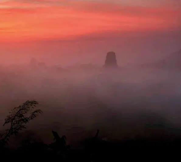  ??  ?? Desde la punta del Templo de la Serpiente Bicéfala, algunas pirámides se develan entre la bruma, cuando los primeros rayos de sol comienzan a calentar la selva.