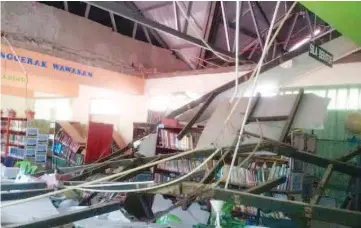  ??  ?? Ceiling in the second-floor library at SMK Agama Mohamad Ali collapsed during the aftershock yesterday morning.