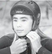  ??  ?? Nalu Deodato straps on his helmet Feb. 14 before surfing in Haleiwa, Hawaii.