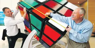  ?? DARREN MAKOWICHUK ?? Wes Nelson, left, and Robert Leedham measure the newest world’s largest functionin­g Rubik’s Cube at Telus Spark on Wednesday. Nelson began working on the $2,500 cube about five weeks ago.