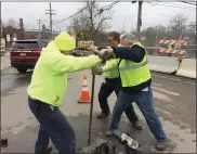  ??  ?? Borough workers, including Public Works Director Doug Yerger, at right, struggle to close a valve to allow repairs on a broken water main to get underway Wednesday.