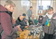  ?? AFP ?? Kherson residents charge their phones at the city's train station, one of the few buildings in the city with electricit­y.