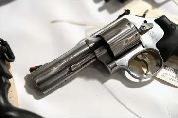  ?? PHOTO BY KEVORK DJANSEZIAN — GETTY IMAGES ?? A handgun seized during sweeps is shown on display at a news conference on May 17, 2013 at the Los Angeles Civic Center in Los Angeles.