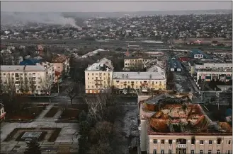  ?? LIBKOS / Associated Press ?? Smoke rises, background, in this aerial view of Bakhmut, the site of the heaviest battles with the Russian troops, in the Donetsk region of Ukraine on Friday.