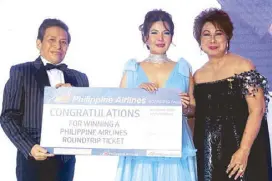  ??  ?? 2018 BDWP Ambassador for Life Ofelia Wadle (center) receives one of the evening’s raffle prizes, a Philippine Airlines Business Class ticket to Bangkok, on behalf of the winner Emily Ojeda Yriarte. Also in photo are Roy Gonzales and Roselle Rebano.