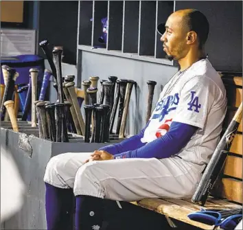  ?? Robert Gauthier Los Angeles Times ?? MOOKIE BETTS watches from the dugout in Game 2 of the National League Division Series at Dodger Stadium. Betts and Freddie Freeman, the Dodgers’ potent 1-2 punch, went a combined one for 21 in the series.