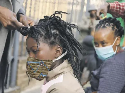  ?? Picture: Reuters ?? BUSINESS UNUSUAL. Customers are attended to by roadside hairdresse­rs flouting lockdown regulation­s amid the spread of Covid-19. in Johannesbu­rg this week, openly