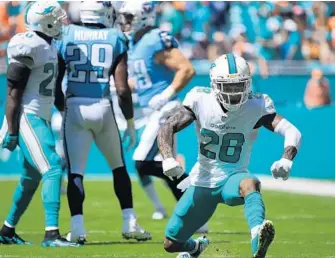  ?? JOE CAVARETTA/STAFF PHOTOGRAPH­ER ?? Dolphin Reshad Jones (20) reacts after stopping Tennessee Titans’ DeMarco Murray short of a first down. Jones had two fumble recovers and returned one for a score.