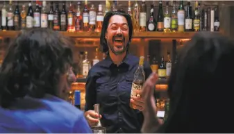  ?? Josie Norris / The Chronicle ?? Bar manager Alex Phillips laughs as he makes a drink. Boot & Shoe management has made respect and positivity priorities in the workplace, aiming for a “new restaurant culture.”