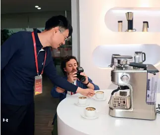  ??  ?? Un joven británico toma una foto de la cafetera a presión elaborada por Xinbao Electrical Appliances Holdings.