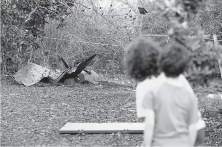  ?? Jack Guez, Getty Images ?? Children look at the remains of a missile that crashed Saturday in Alonei Abba, east of Haifa, in northern Israel. Israel struck a dozen Syrian and Iranian targets inside Syria in “large-scale” raids after an Israeli fighter jet crashed under fire from...