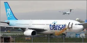  ?? ?? The Canadian Press
Air Transat aircraft lands on the tarmac at Montreal-Trudeau Internatio­nal Airport in Montreal.