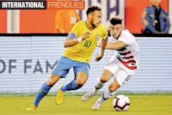  ?? — AFP ?? Brazil’s Neymar (left) vies for the ball with USA’s Paul Arriola in their friendly match at the Metlife Stadium in East Rutherford, New Jersey on Friday. Brazil won 2-0.