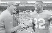  ?? JOHN MCCALL/SUN SENTINEL ?? Kenyan Drake celebrates with special teams coordinato­r Darren Rizzi in the end zone after scoring a touchdown on the final play of the game to defeat the Patriots.