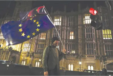  ?? REUTERS ?? AN ANTI-BREXIT supporter marches outside the Houses of Parliament in Westminste­r, London in this March 12 photo.