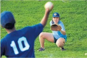  ??  ?? Hannah Sawa, 15, helps a pitcher warm up during a youth league baseball game at Dumbarton Middle School.